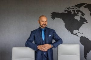 Rafał Brzoska, prezes InPostu w garniturze przy biurku.