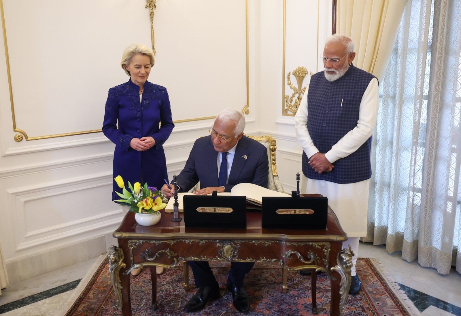 Podpisywanie dokumentu przez Ursulę von der Leyen i Narendrę Modiego w eleganckim wnętrzu.