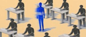 Osoba w niebieskim wśród innych pracujących osób przy biurkach