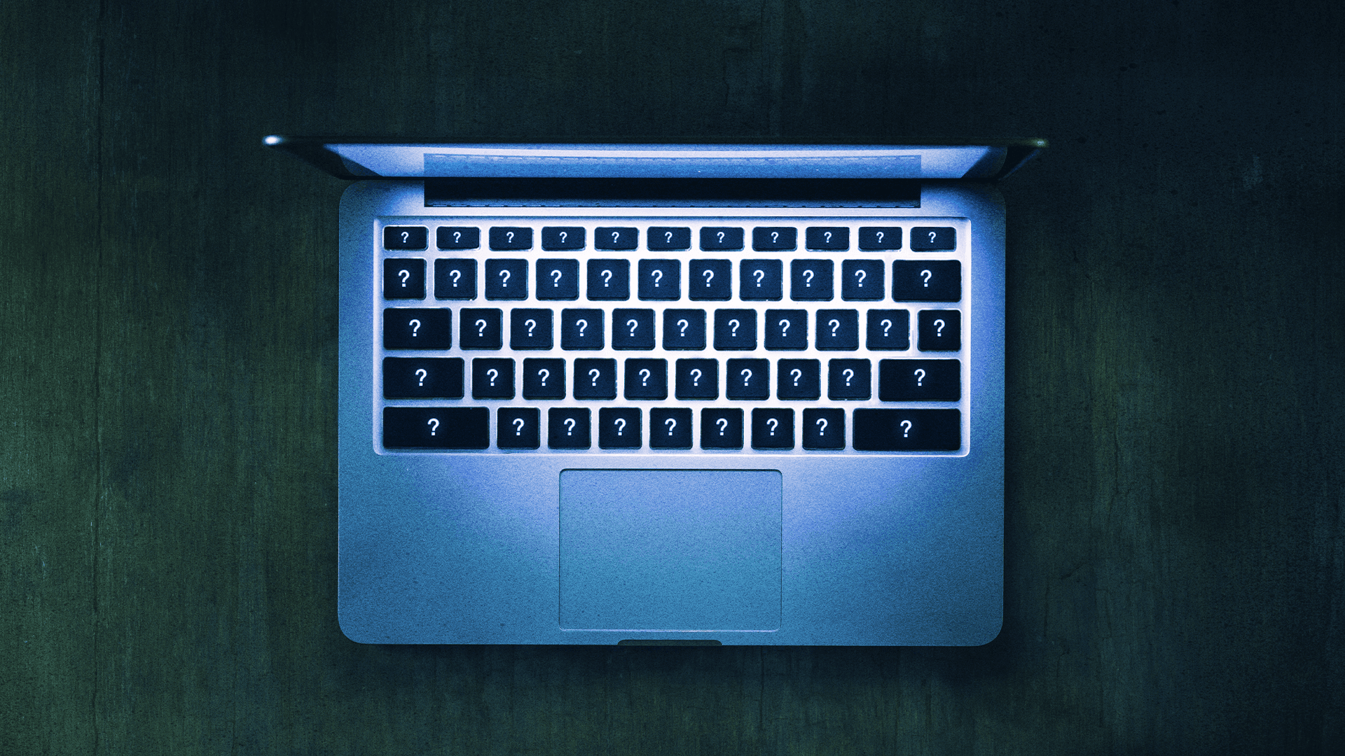 Laptop z podświetloną klawiaturą. Na każdym klawiszu znajduje się znak zapytania.