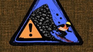 Grafika przedstawiająca górnika na nartach zjeżdżającego z hałdy węgla. Obok niej umieszczony jest znak ostrzegawczy