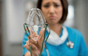 Smutna pani trzyma aparat do tlenoterapii