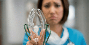 Smutna pani trzyma aparat do tlenoterapii