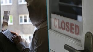 Zdjęcie podzielone na dwie części. Po lewej mężczyzna z kapturem na głowie siedzi na parapecie i trzyma laptopa na kolanach. Za oknem blok z wielkiej płyty. Po prawej drzwi z tabliczką "Closed" na witrynie