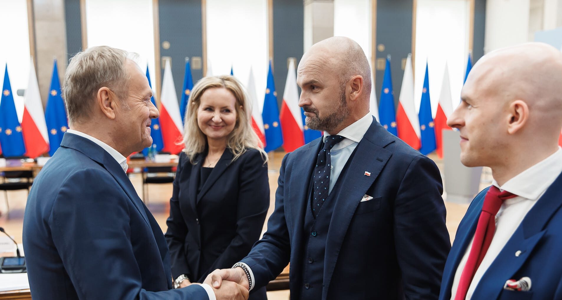 Premier Donald Tusk ściskający rękę Rafała Brzoski. Przyglądają się temu Magdalena Burnat i Ryszard Chmura