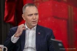 Prezydent Karol Nawrocki w trakcie wywiadu z mikrofonem na policzku