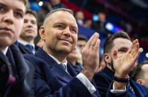 Prezydent Polski Karol Nawrocki siedzi i klaszcze wśród tłumu