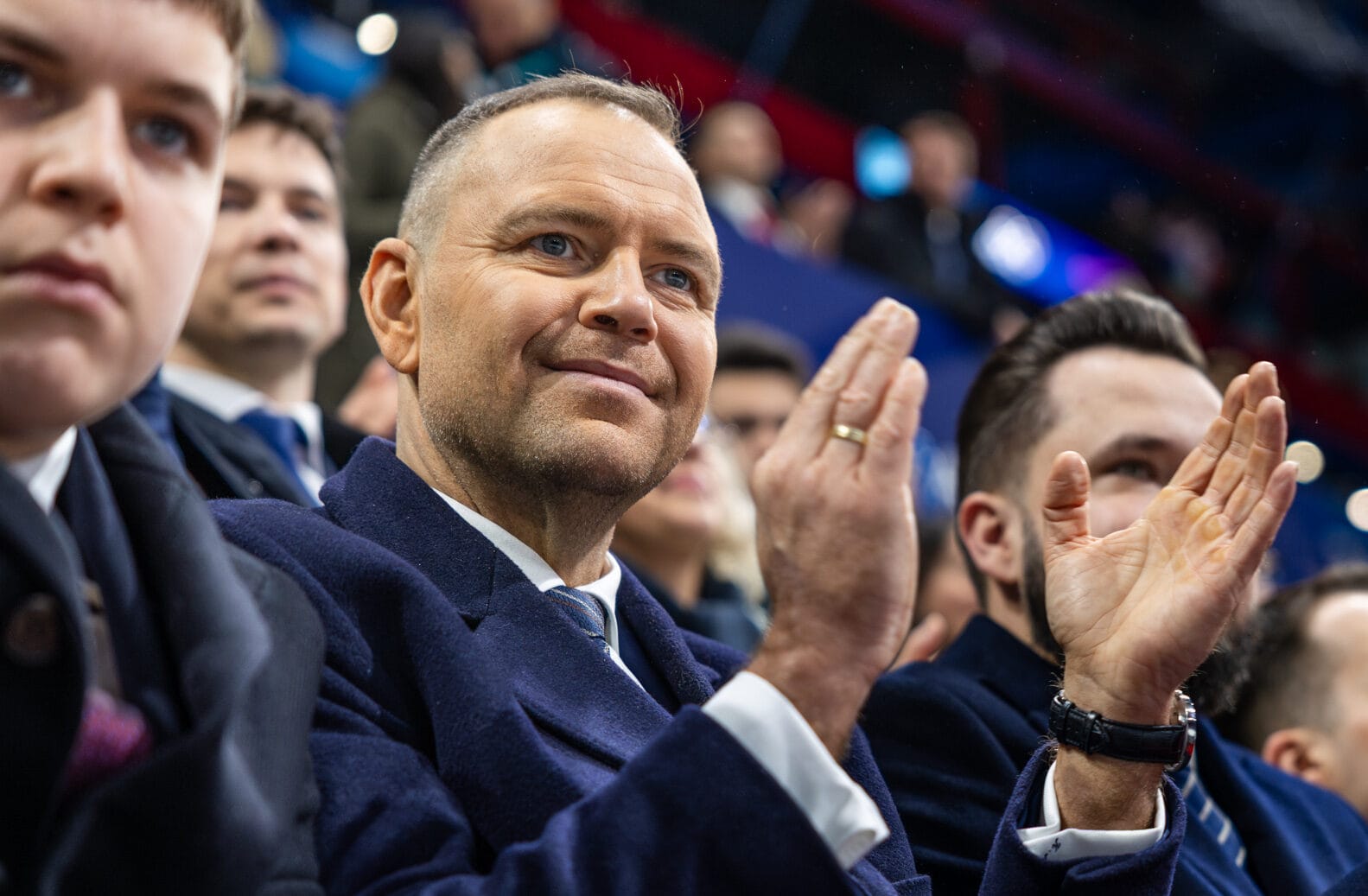 Prezydent Polski Karol Nawrocki siedzi i klaszcze wśród tłumu