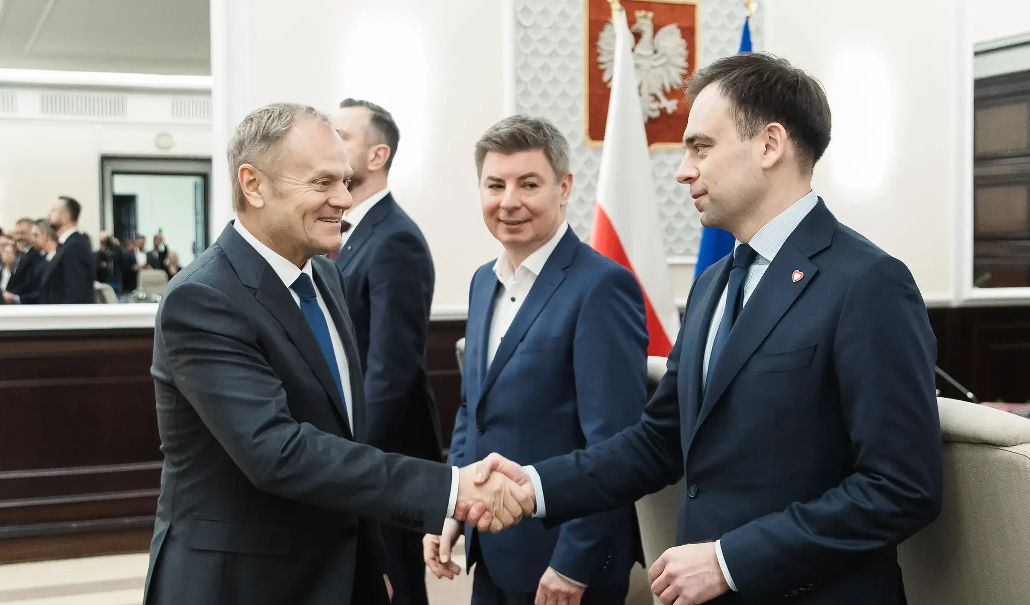 Uścisk dłoni Donalda Tuska i Andrzeja Domańskiego w Kancelarii Premiera. W tle przygląda się temu Jan Grabiec