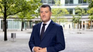 Leszek Skiba w garniturze na zewnątrz.