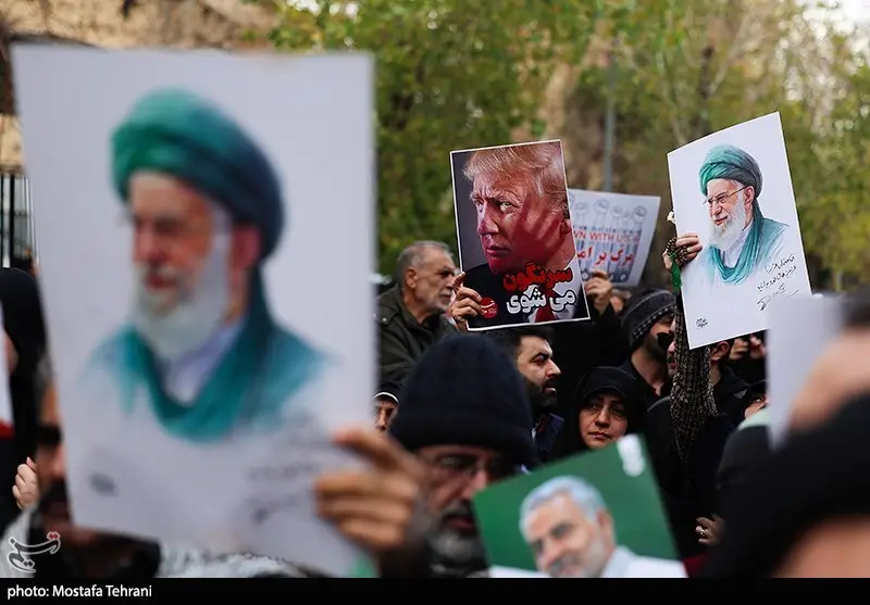 Osoby trzymające plakaty rozdane przez Tasnim News podczas pogrzebu osób, które zginęły w trakcie protestów