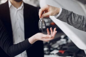 Na zdjęciu widać moment przekazania kluczyków samochodowych w salonie.