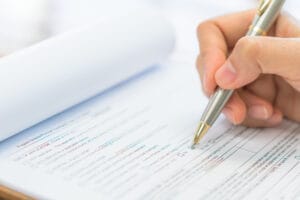Osoba wypełniająca formularz długopisem.