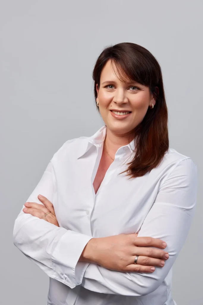 Agata Kotwica-Stefańska w białej koszuli, uśmiechnięta.