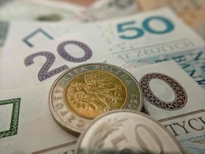 Polskie banknoty 50- oraz 20-złotowy, a także monety 5 zł i 50 gr na stole