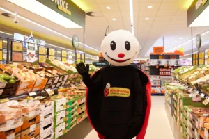 Maskotka Biedronki w sklepie sieci na tle półek