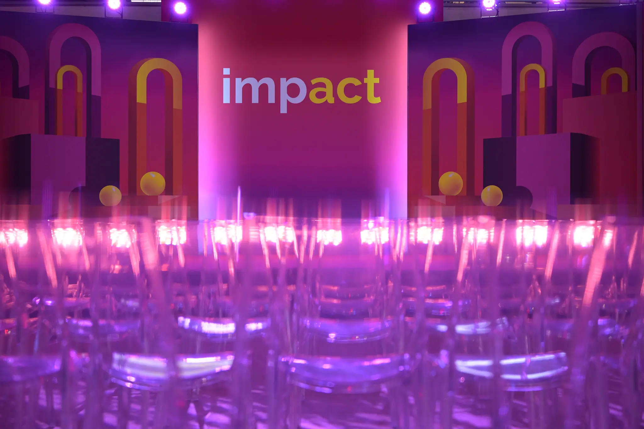 Scena wydarzenia Impact'26 z różowymi światłami i krzesłami