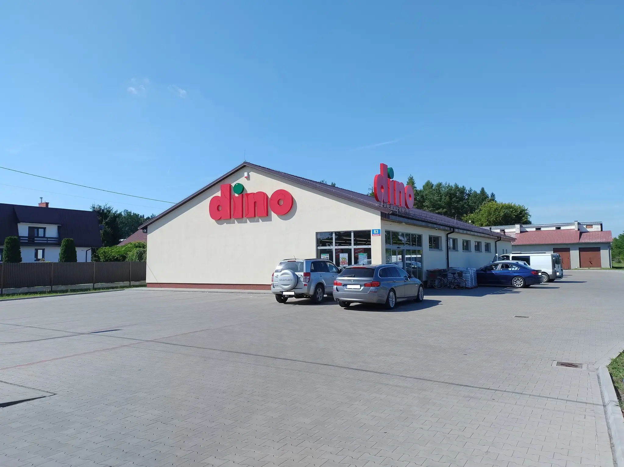 Sklep Dino z samochodami na parkingu.
