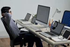 Zdjęcie przedstawia osobę pracują przy komputerze w biurze.