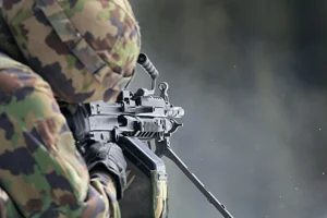 Żołnierz celujący z karabinu w kamuflażu