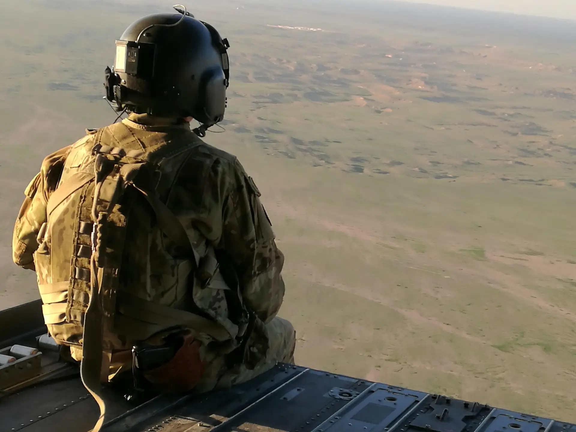 Żołnierz siedzący na helikopterze.