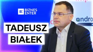 Tadeusz Białek w garniturze w trakcie wywiadu. Po lewej stronie logo Biznes Enter i podpis Tadeusz Białek