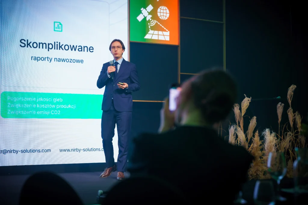 Piotr Lazarek w garniturze przemawia na konferencji technologicznej Huawei Startup Challenge.
